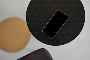 Un teléfono celular sentado encima de una mesa negra