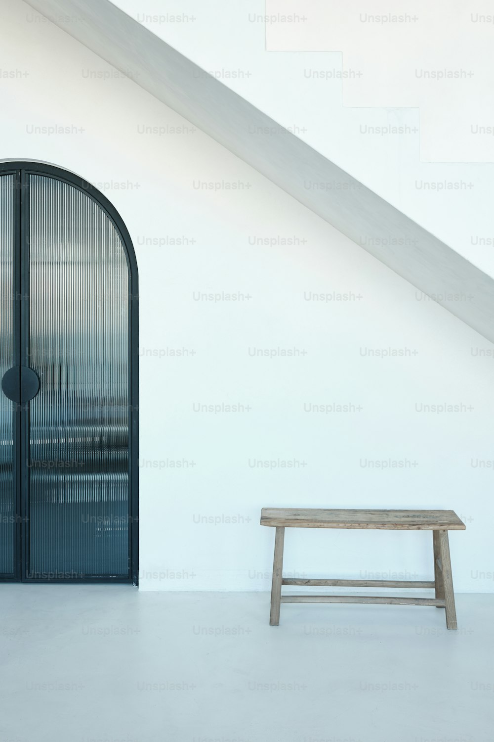 a wooden bench sitting in front of a glass door