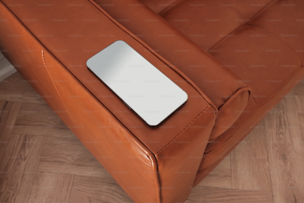 um close up de um sofá com um controle remoto sobre ele