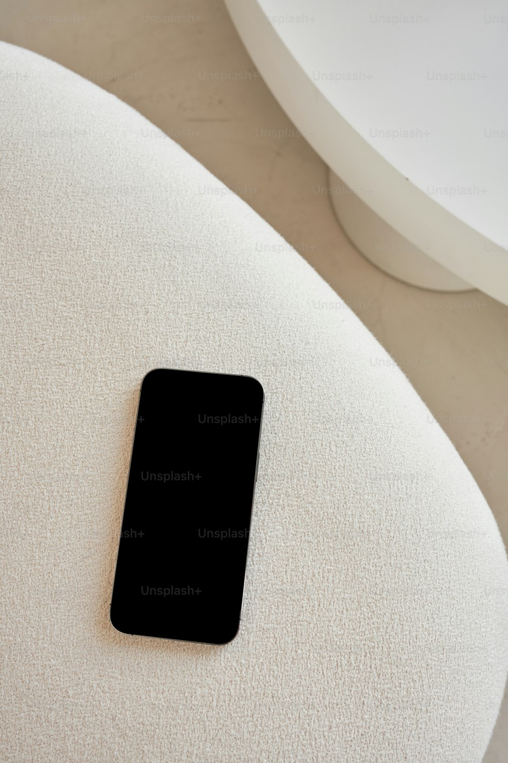 um telefone celular preto sentado em cima de uma cadeira branca
