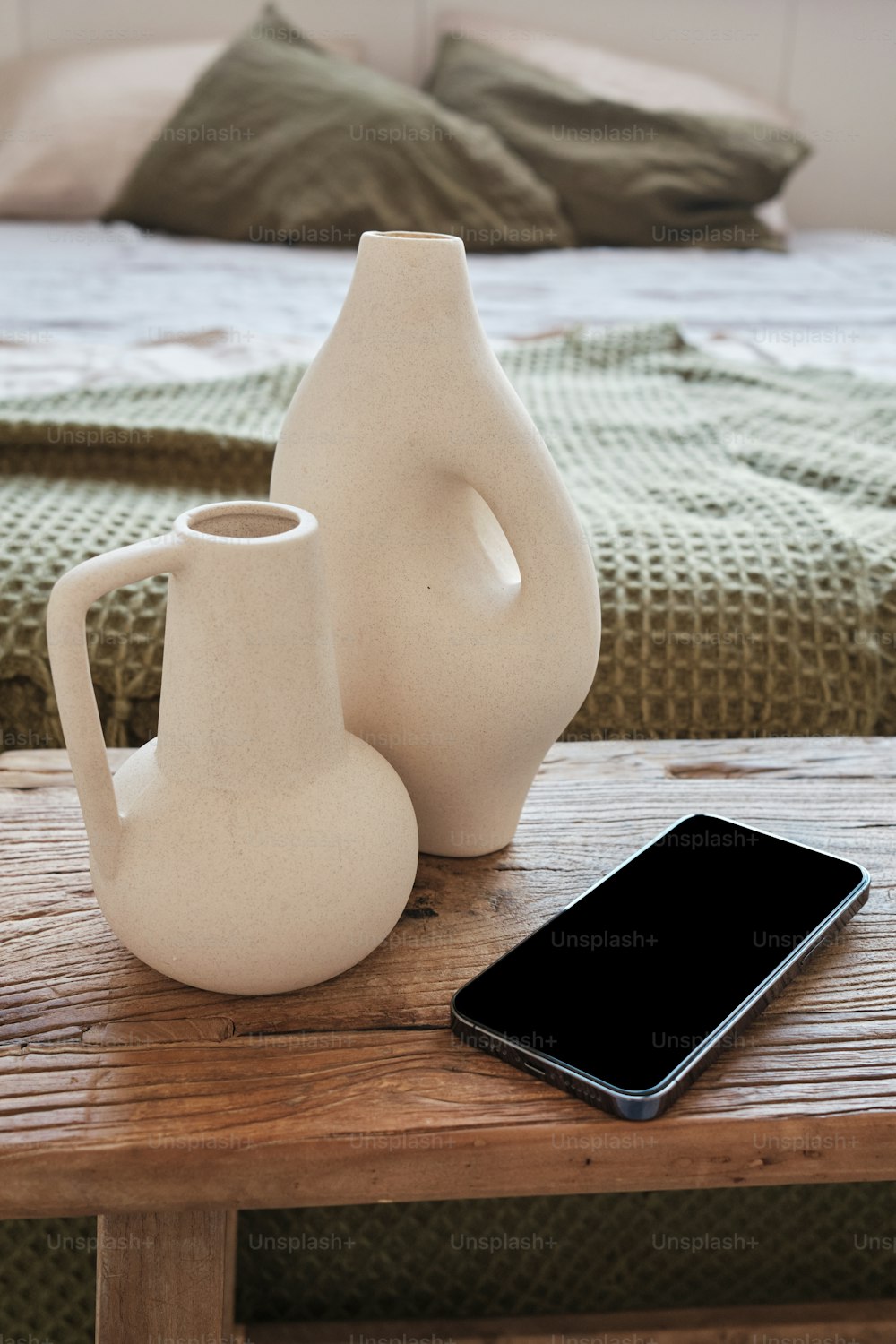 a table with a phone and a vase on it