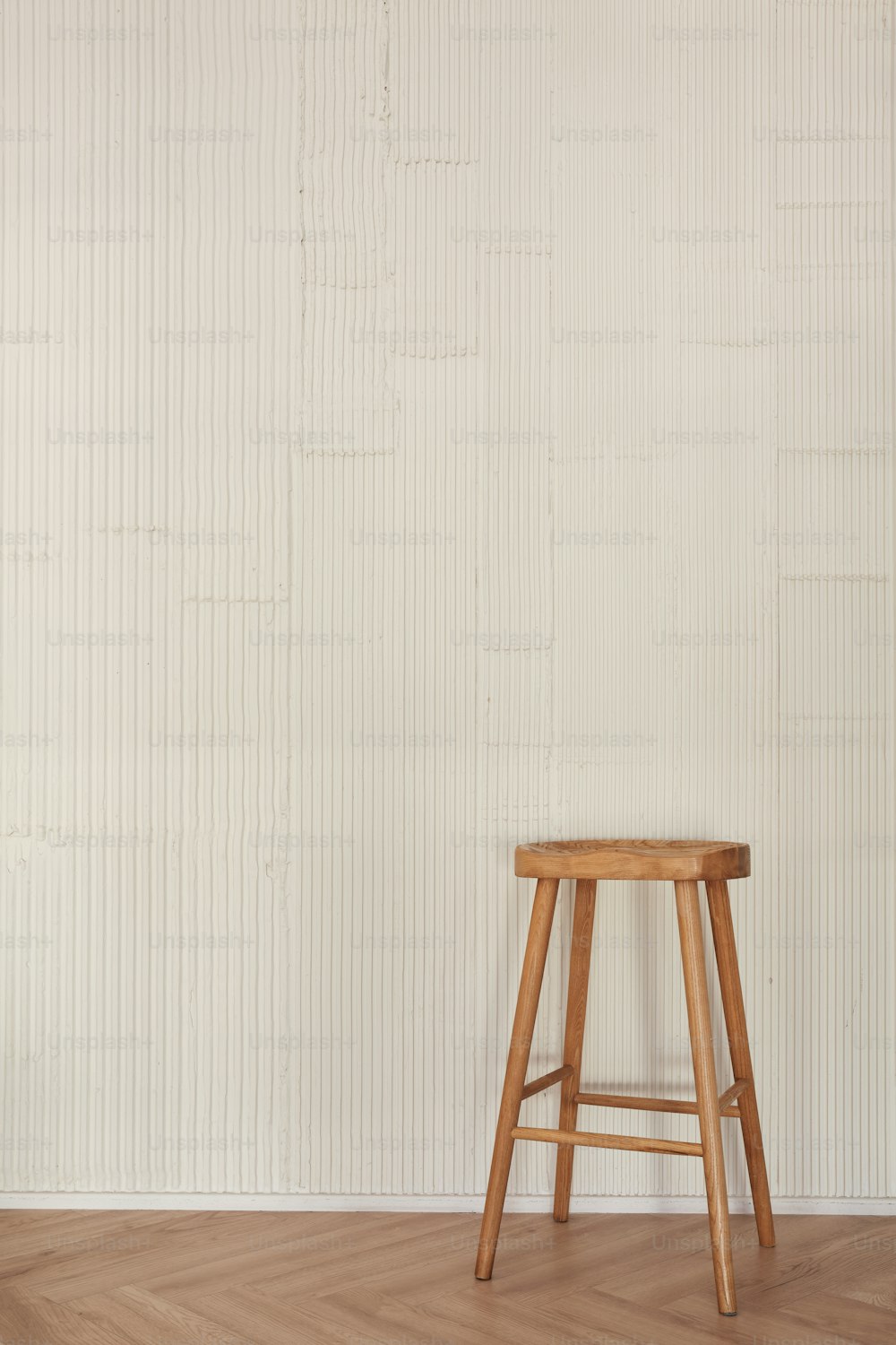 a wooden stool sitting on top of a hard wood floor