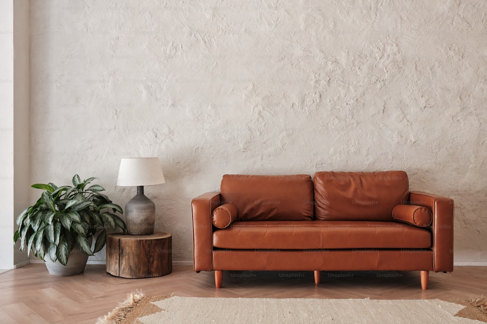 a living room with a leather couch and a potted plant
