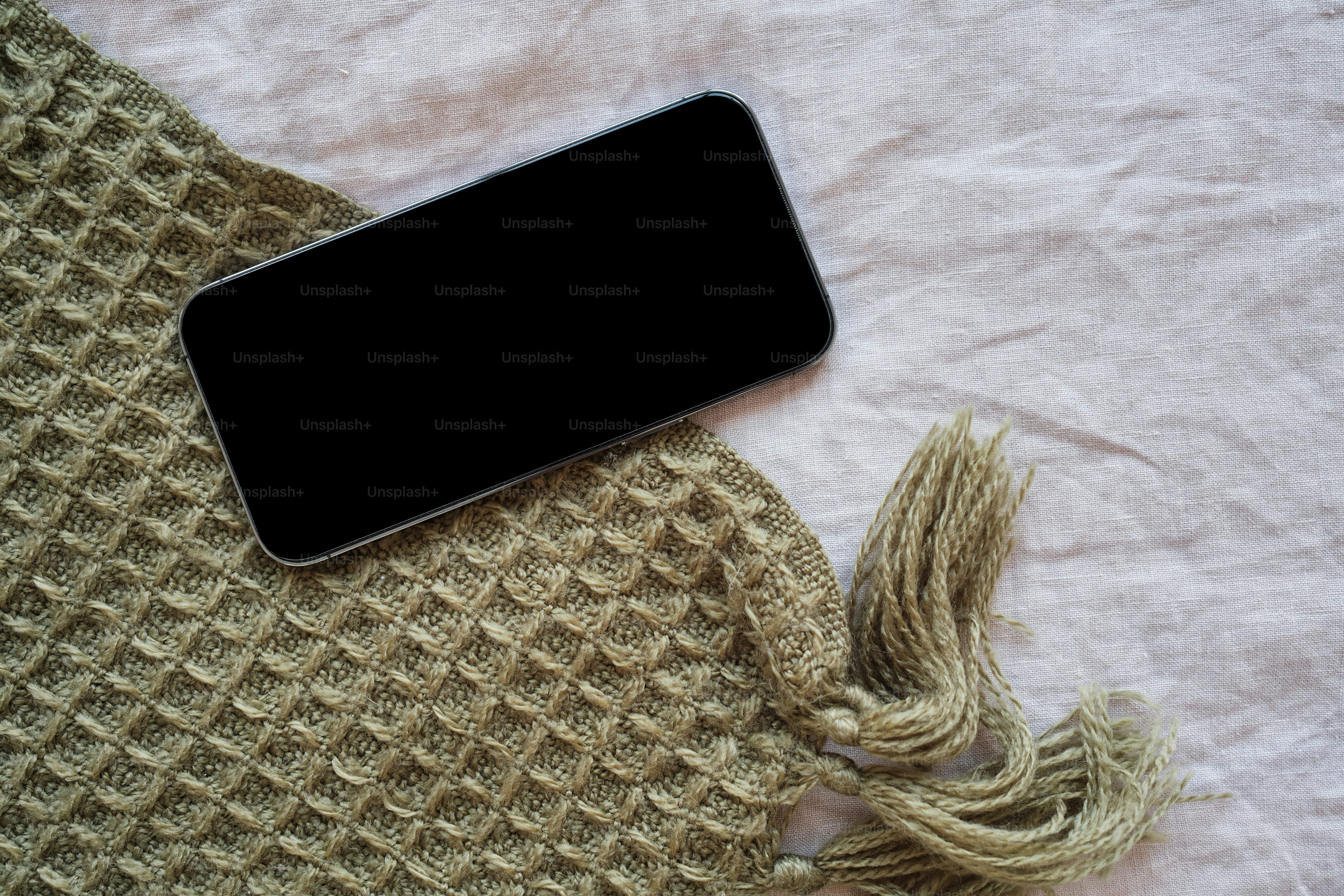 A cell phone laying on top of a blanket photo Blankets Image on Unsplash