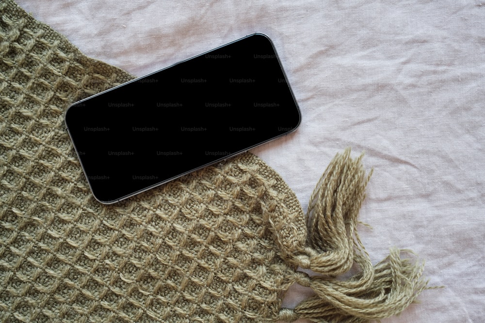 un telefono cellulare appoggiato sopra una coperta