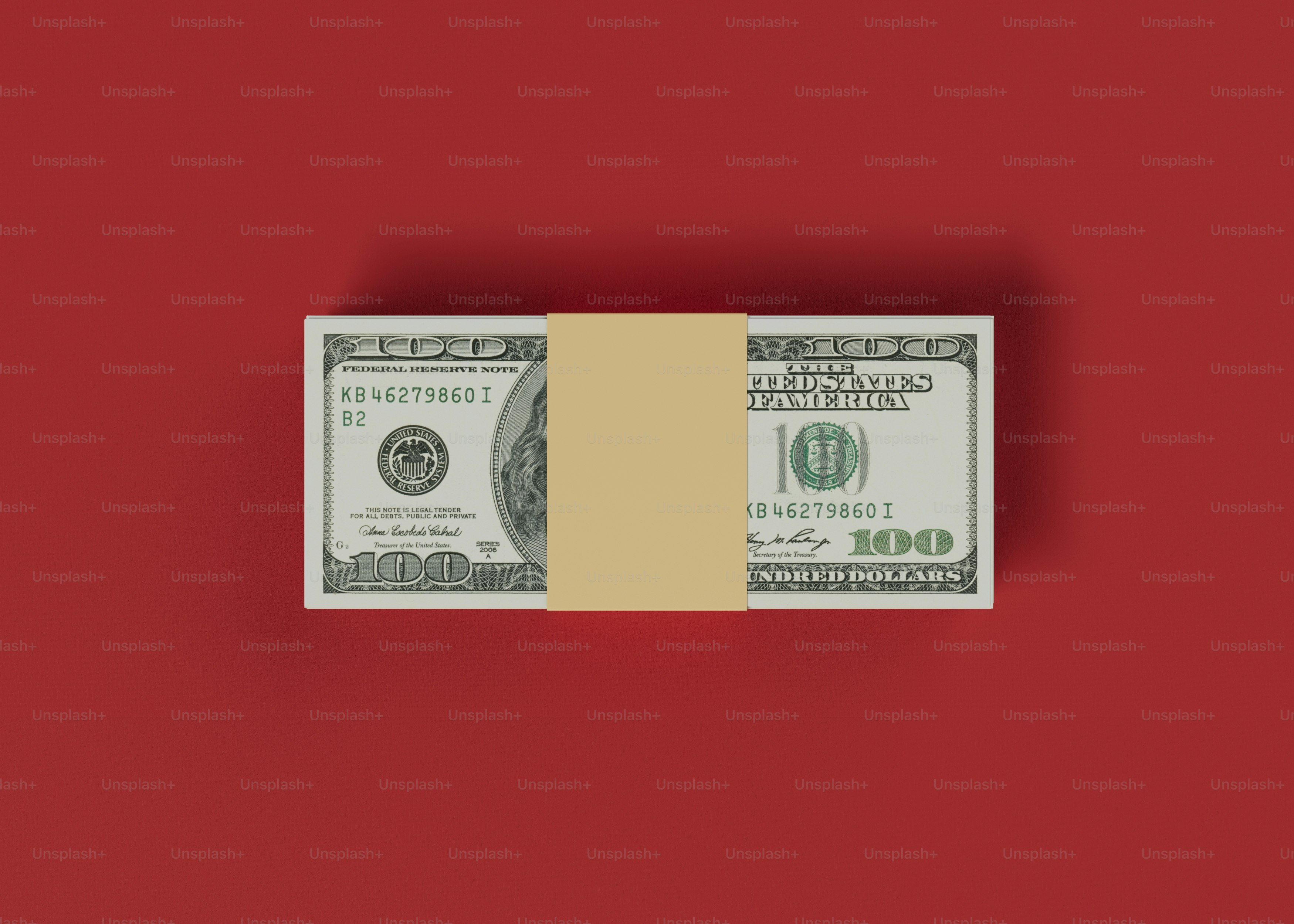 ein Stapel von Hundert-Dollar-Scheinen auf rotem Hintergrund