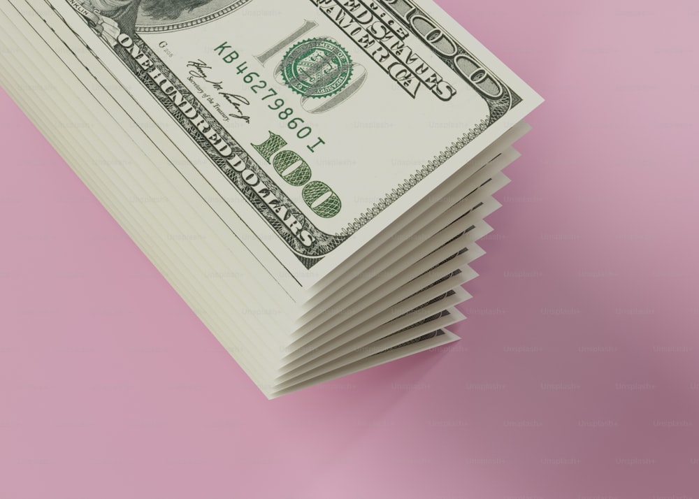 a stack of twenty dollar bills on a pink background