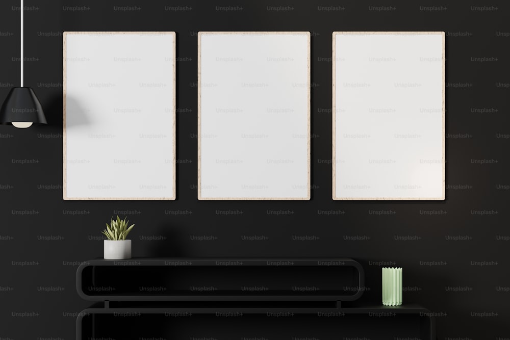 a black room with three white frames on the wall