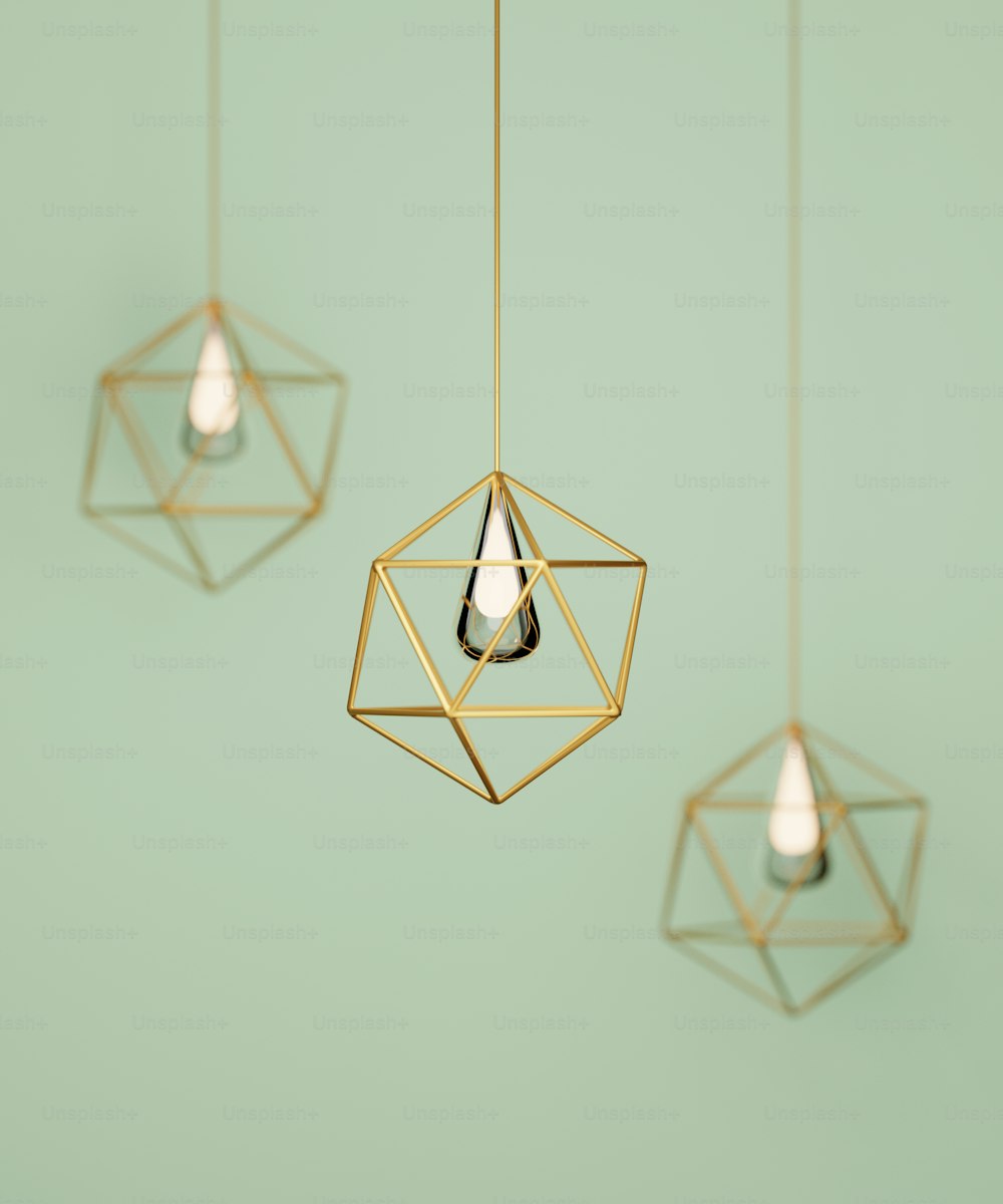 a group of three hanging lights on a green wall