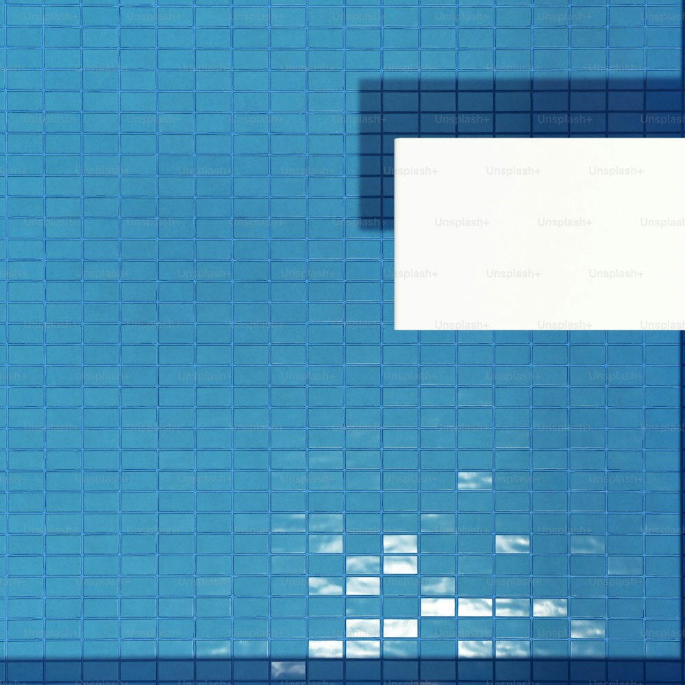 a blue tiled wall with a white square in the middle