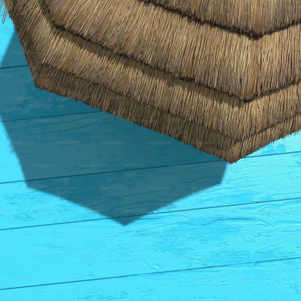 Der Schatten eines Strohdaches auf einer blauen Holzwand