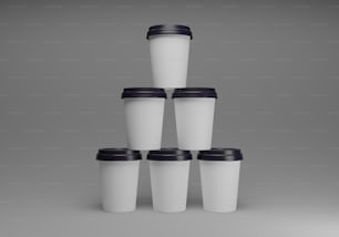 a stack of white coffee cups with black lids