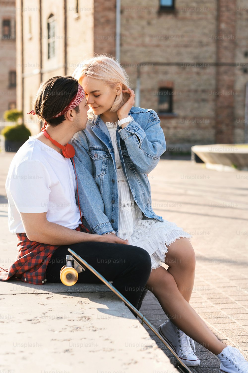 Stylish teenage couple with a longboard during their date in a city