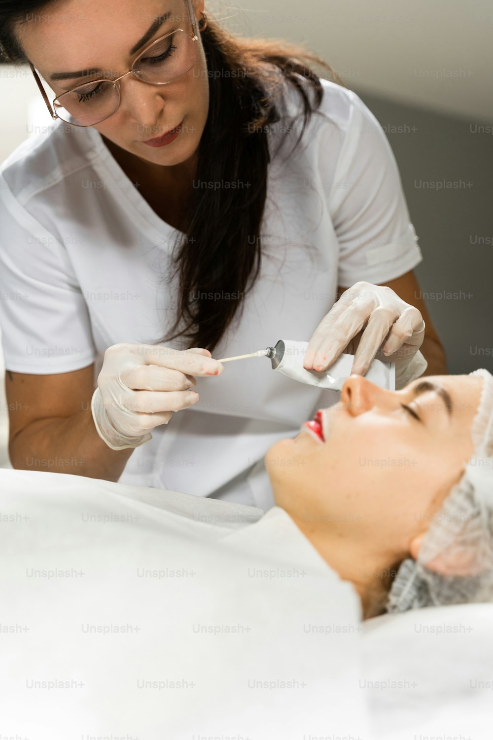 Professional permanent make-up artist and her client during lip blushing procedure