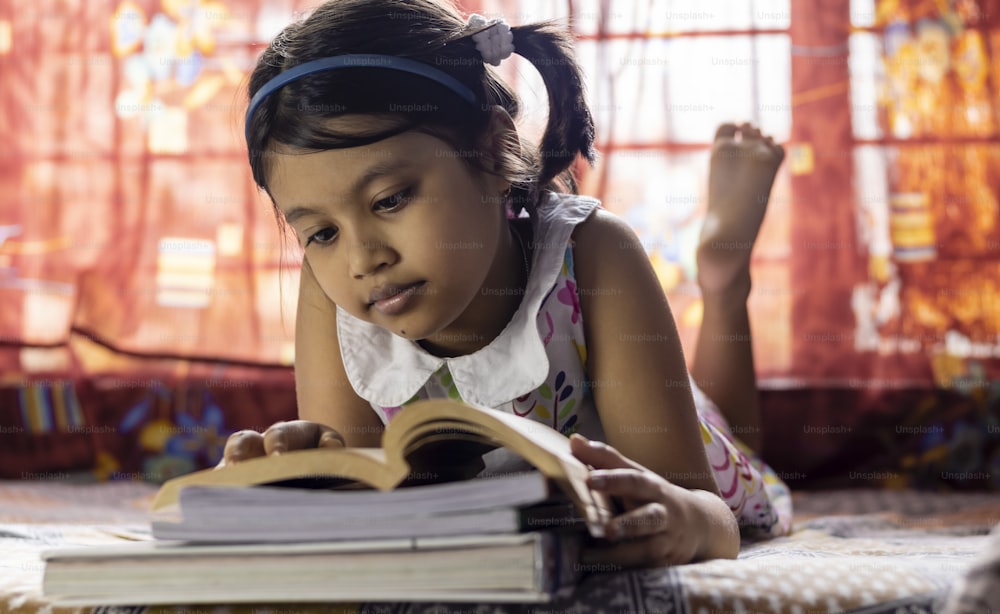 una bambina indiana sveglia che studia a casa con la faccia sorridente