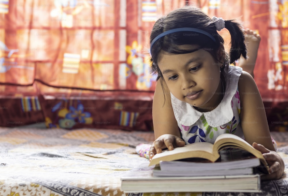 an Indian cute girl child studying at home with smiling face