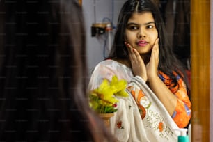 uma bela mulher indiana em saree branco olhando-se no espelho com rosto sorridente