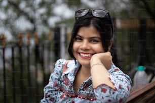Portrait of a pretty Indian woman with sunglasses on head smiling and looking at camera