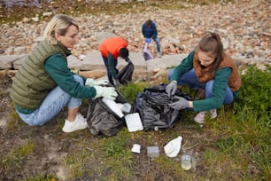 Un groupe de bénévoles nettoie les ordures dans des sacs qu’ils protègent et sauvent la nature