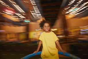 African little girl smiling at camera while riding on a swing in the park