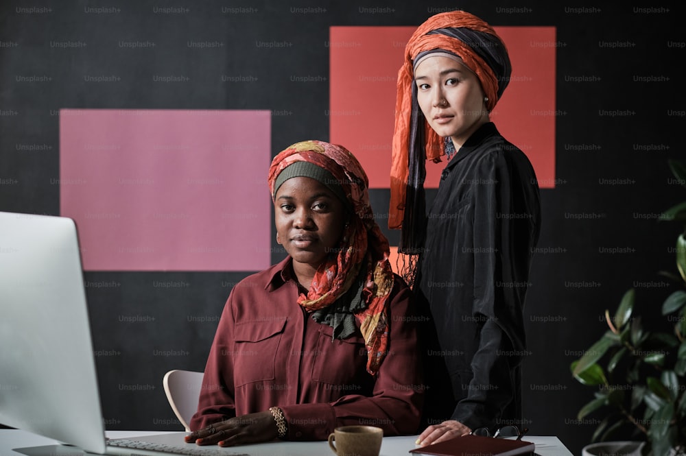 Portrait of muslim businesswomen looking at camera while working at the table on computer at office