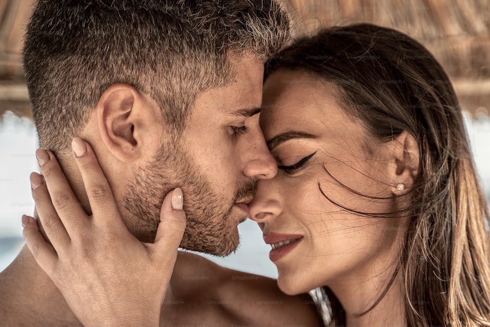 Retrato de una atractiva pareja enamorada abrazándose. Foto en primer plano de jóvenes hermosos abrazándose y besándose. Momento romántico. Día de San Valentín. Luna de miel.