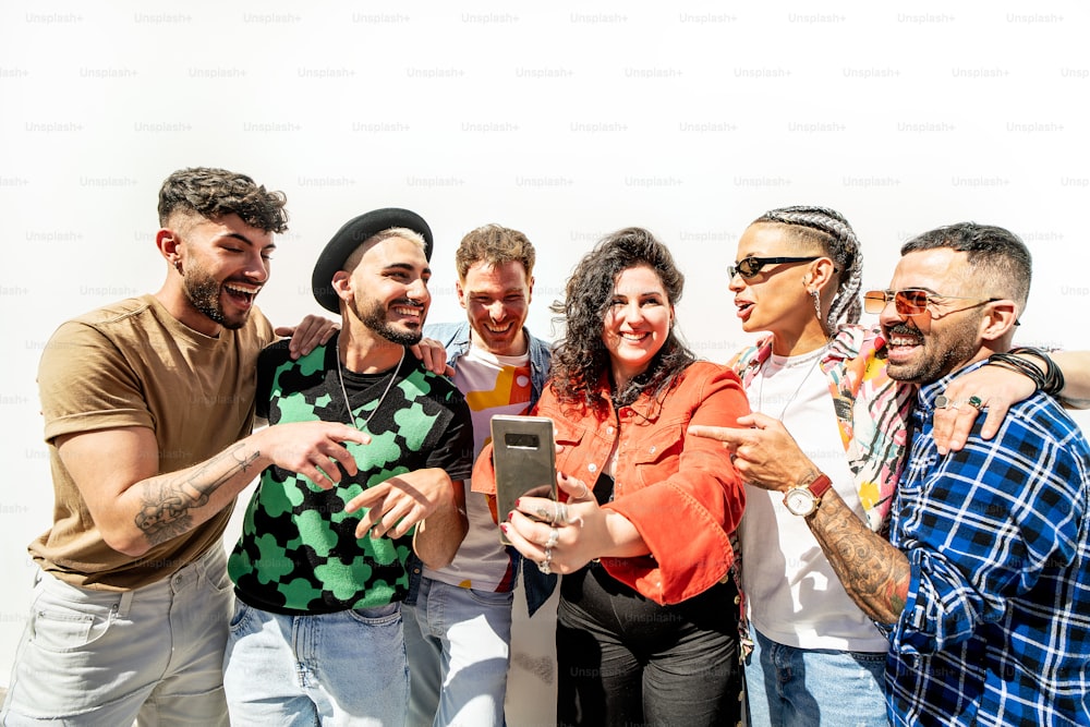 Group of happy multicultural friends looking at social media on the mobile phone and having fun together, laughing. Friendship. Real people emotions. Tourism. Travel.