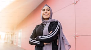 Porträt einer attraktiven muslimischen sportlichen Frau mit Hijab im Freien