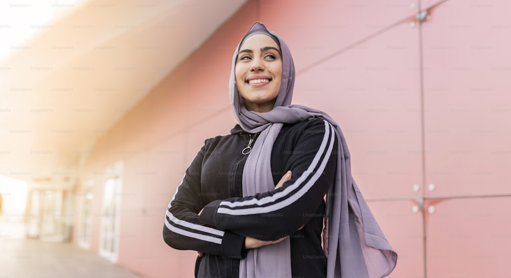 retrato da mulher esportiva muçulmana atraente com hijab ao ar livre