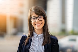retrato hispânica empresária usando óculos sorrindo ao ar livre