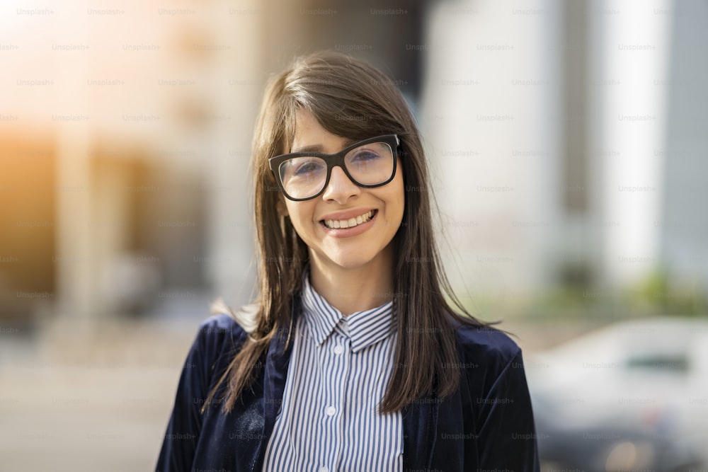 Porträt hispanische Geschäftsfrau mit Brille, die im Freien lächelt