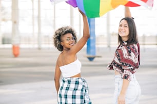 two protesting friends walk happily while holding a lgbt flag