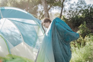 a woman holding a blue and white tent