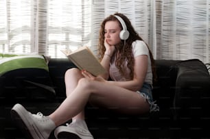 portrait of young woman ginger reding a book with bored face