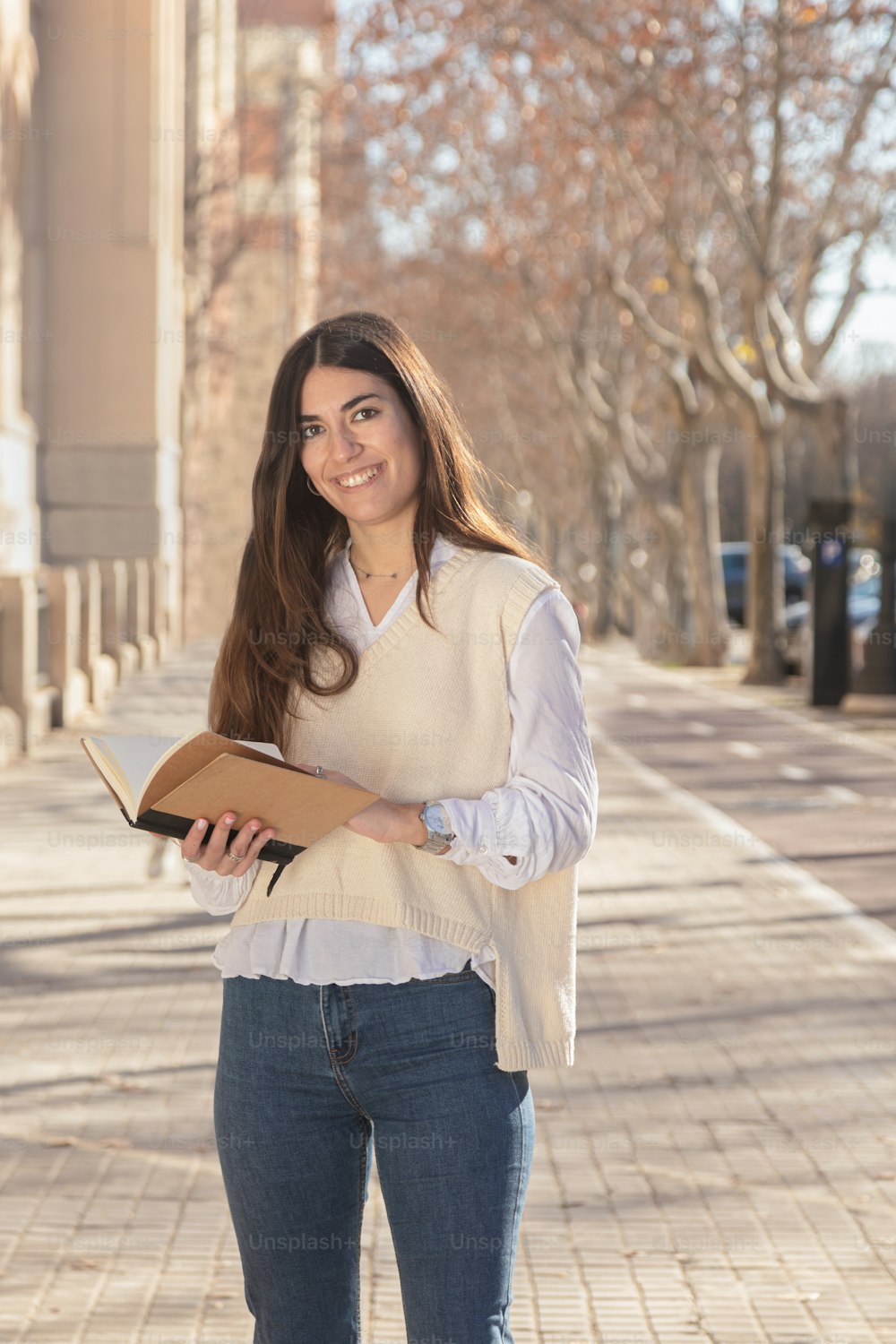 Étudiante souriant en regardant la caméra. Jeune femme avec un cahier à la main sur le campus universitaire. Retour en classe