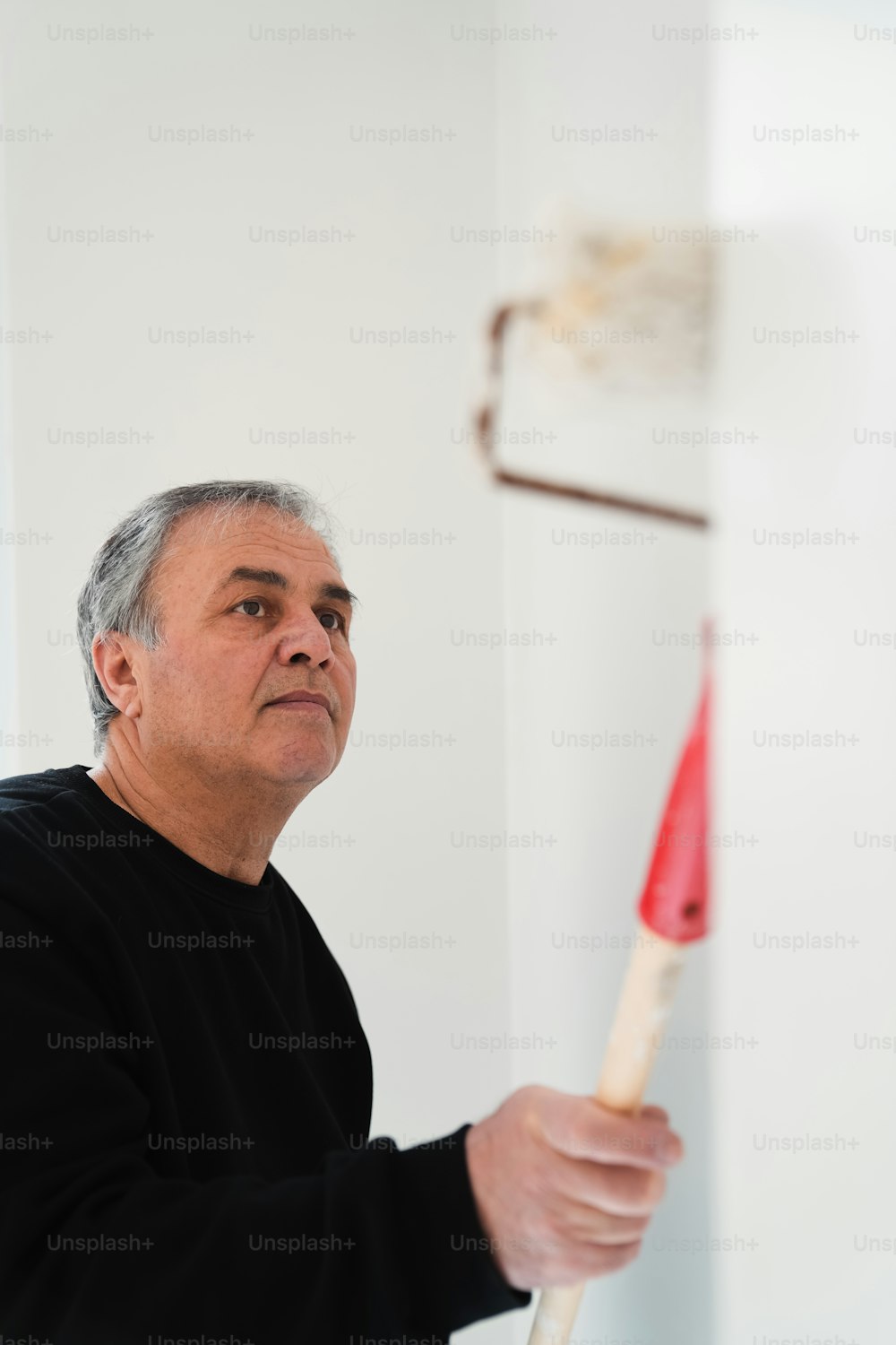 a man holding a baseball bat in a room