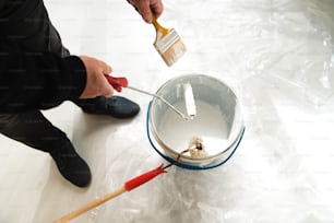 a person is painting a bucket with a brush