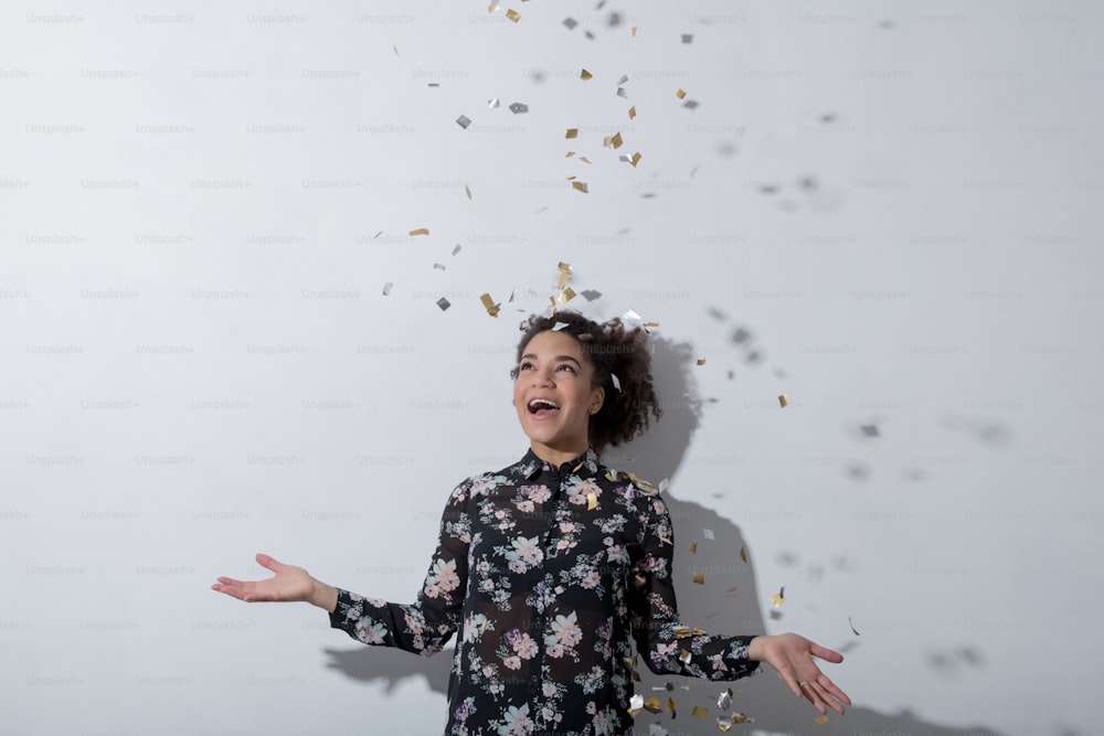 Young woman enjoying the party with confetti in air