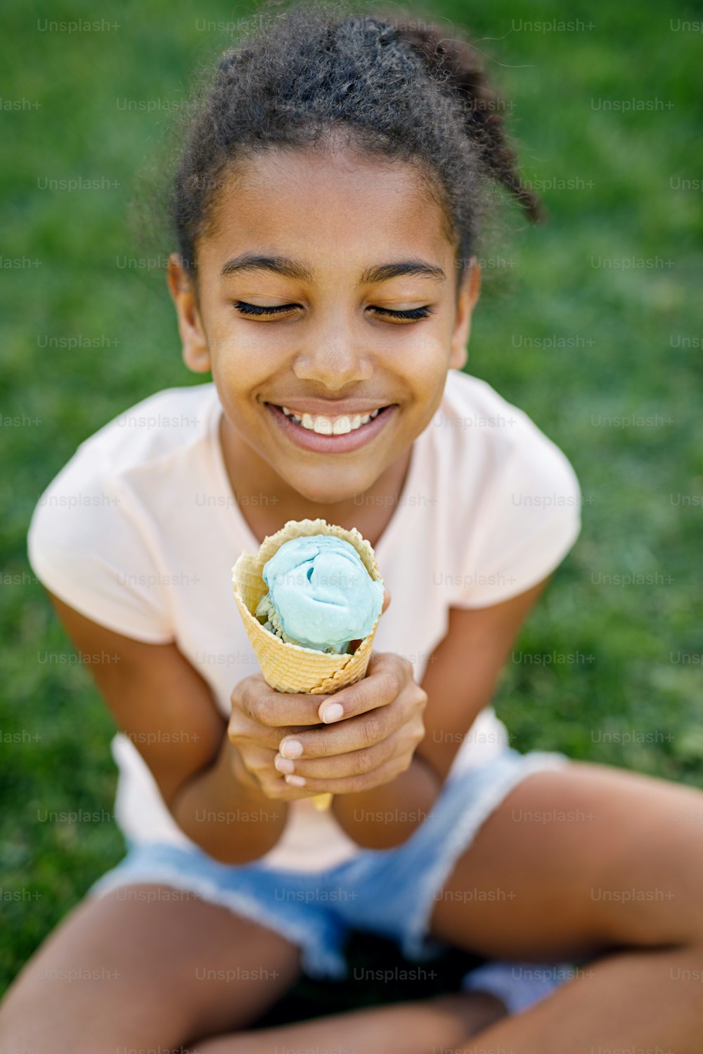 공원에 앉아 아이스�크림을 들고 있는 행복한 소녀