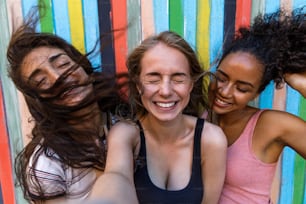 Giovani donne che scattano selfie all'aperto mentre il vento soffia i capelli