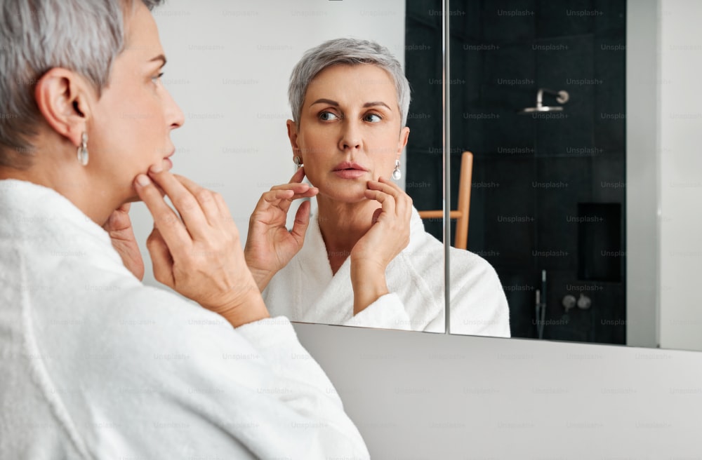 Mature woman with short grey hair wearing bathrobe