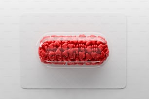 Pilule transparente avec des cœurs de bonbons rouges couchés sur un tableau blanc sur fond blanc. Concept de célébration de la Saint-Valentin. Rendu 3D