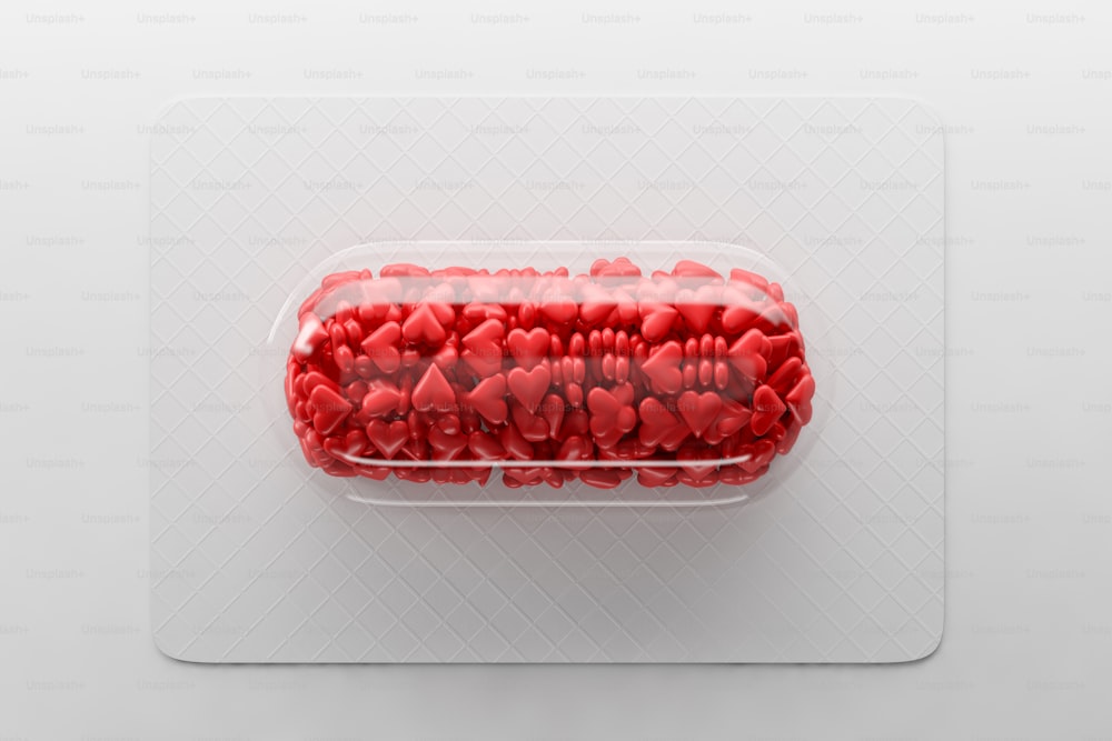 Pillola trasparente con cuori di caramelle rosse che giacciono sulla lavagna bianca su sfondo bianco. Concetto di celebrazione di San Valentino. Rendering 3D