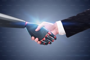 Man and robot shaking hands over dark gray wall background. Concept of automation and artificial intelligence.
