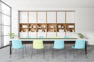 白い会議室の内部にカラフルな椅子と、灰色のコンクリートの床に植物。オフィスのミニマリストコンサルティングルーム、ドキュメント付きの棚、シティビューの窓、3Dレンダリング