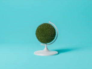 Gras Erde Kugel auf blauem Hintergrund. Minimales Konzept von Ökologie und Umwelt. 3D-Rendering