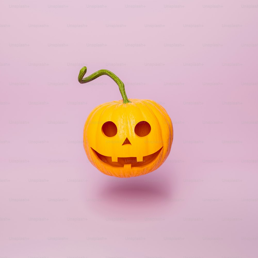 Citrouille d’Halloween avec un visage heureux et une longue tige flottant sur fond rose minimal. Concept d’automne et de nuit des sorcières. Rendu 3D