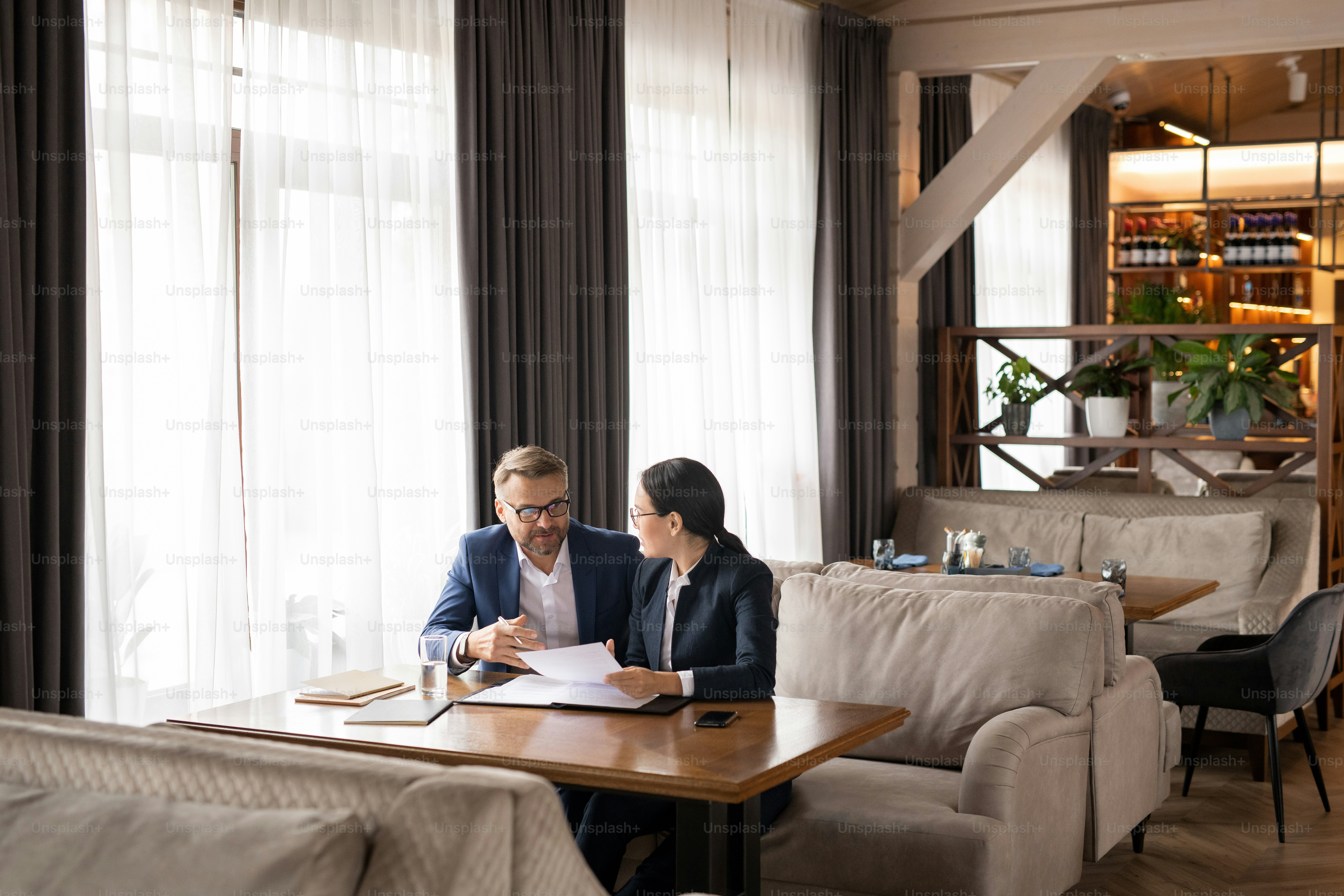 Two professionals reviewing documents in a restaurant setting