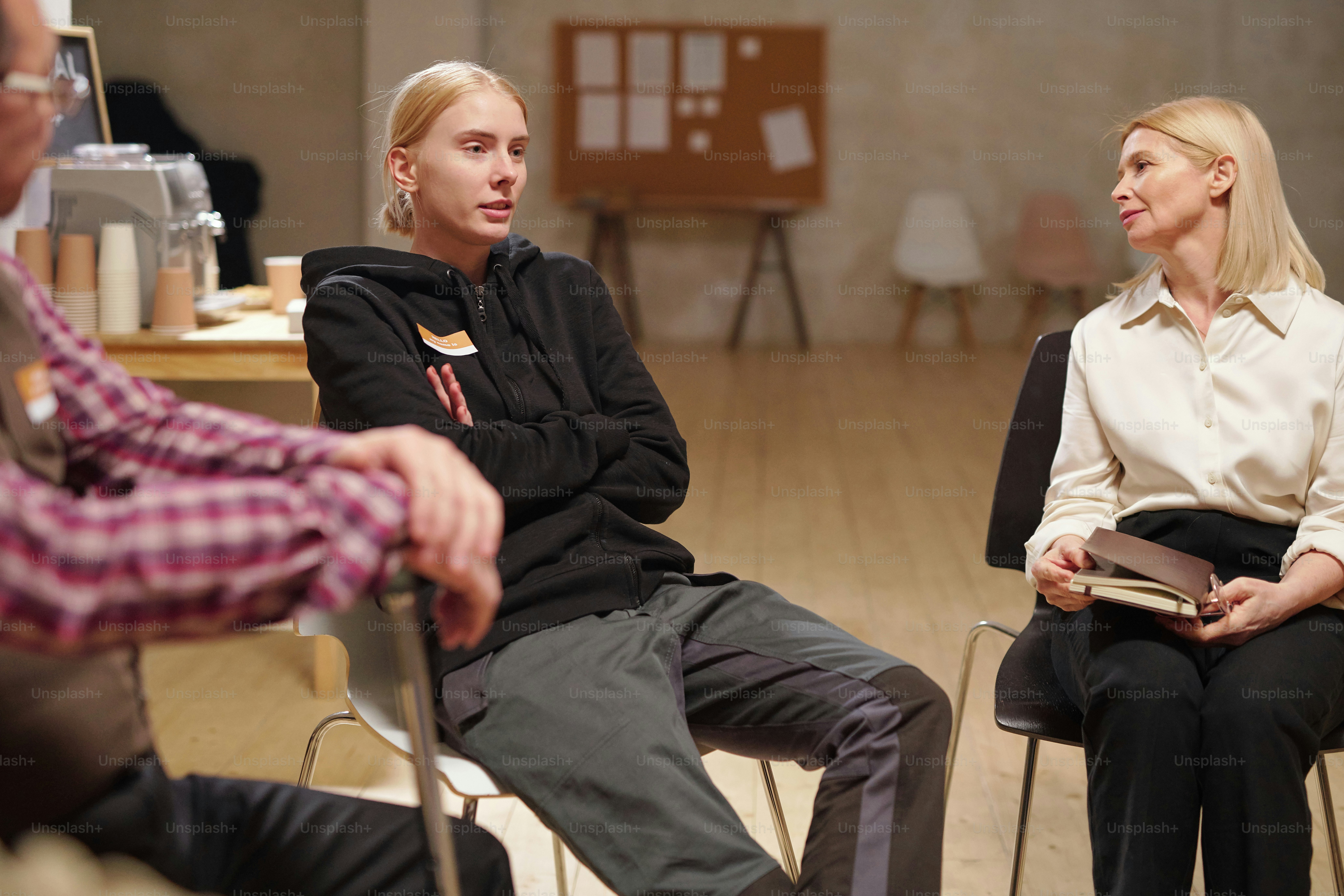 Young female patient of psychological course describing her problem to others