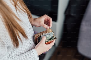 Una mujer sosteniendo una billetera en la mano